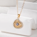 Macro shot of evil eye pendant with blue inlay and crystals on golden chain - Teardrop Eye Style