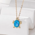 Macro shot of gold turtle pendant with blue opal shell and crystal details on white stand - Turtle (Stainless Steel Chain) / Blue Sea Turtle