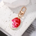 Portachiavi ovale boho con motivo marmorizzato e chiusura dorata su una pietra bianca - Ovale Rosso Bianco
