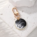 Detailed close-up of Bohemian alloy keychain with black and white enamel ink swirl pattern - Round Black White