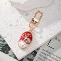 Macro detail of oval pendant keychain with red enamel, pearls, and crystals inlay - Red Pearl (Retro Oval)