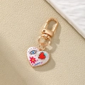 Dettaglio portachiavi a cuore in smalto bianco con graffiti evil eye e moschettone dorato - Stile Malocchio Onda Blu (9#)