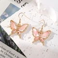 Orecchini a farfalla con fiori secchi rosa e montatura dorata in stile romantico - Farfalla Simmetrica Rosa