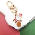 Süßer Weihnachtsmann-Emaille-Schlüsselanhänger mit goldfarbenem Haken auf festlichem Hintergrund - Weihnachtsmann