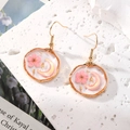 Dettaglio di orecchini dorati con fiori secchi rosa e resina dentro ciondolo a cuore - Luna di Fiori Rosa Rotonda Piccola Irregolare