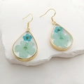 Detailed close-up of water drop earrings featuring blue dried flowers in transparent resin - Earrings / Light Blue