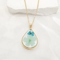 Detail of teardrop pendant necklace featuring natural blue dried flowers in gold frame - Necklace / Light Blue