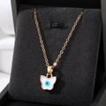 Elegante goldene Schmetterlingskette mit blauem Evil-Eye-Anhänger in einer Schmuckschatulle - Weißer Schmetterling