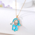 Golden Hamsa hand necklace with blue enamel evil eye and sparkling rhinestones - Blue Hollow Hand