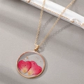 Detail of round gold pendant with real pink heart flower petals and gold foil accents - January Carnation (Necklace)