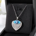 Detailed close-up of heart-shaped evil eye pendant with blue crystals in jewelry box - Silver Fan Shape Eye