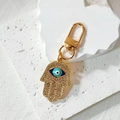 Close-up of golden Hamsa Hand keychain with crystal pavé and blue enamel evil eye charm - Hamsa Hand Style / Blue Eye Full Rhinestone Hamsa