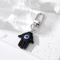 Hamsa-Hand Schlüsselanhänger mit blauem Evil Eye Anhänger auf weißem Stein - Schwarz