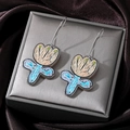 Detail of floral drop earrings with colorful tulip charms on satin background texture - Orange Flower