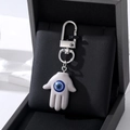 Porte-clés main de Fatma blanc avec charme mauvais œil bleu et mousqueton argenté - Gris