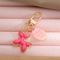 Detail of pink resin balloon dog keychain with gold metal trim and oval pendant tag - Rose Red Balloon Dog