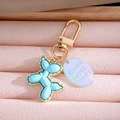 Blue balloon dog keychain with gold edges and translucent tag on pink leather background - Sky Blue Balloon Dog