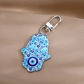Detail of Hamsa hand keychain with blue floral patterns and evil eye on silk fabric - 20# Sky Blue Elephant