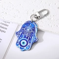 Detail of blue Hamsa Hand keychain with Evil Eye pattern on a white stone base - Blue Round Eye