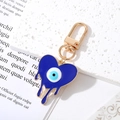 Dark blue Evil Eye heart keychain with gold lobster clasp on a minimalist background - Gold Heart