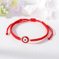Close-up of handmade red braided cord bracelet with gold-edged evil eye charm detail - Red And White Round Eye