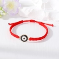 Detail of red woven Evil Eye bracelet with golden metal trim and adjustable clasp - Black And White Round Eye