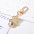 Dettaglio del portachiavi Mano di Fatima con motivo Evil Eye e trama in rilievo dorata - Mano di Fatima Grande Occhio Grigio Oro