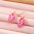 Macro shot of geometric pink crystal earrings on a pink leather jewelry display tray - Pink