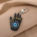Vintage Hamsa-Hand Schlüsselanhänger mit blauem Auge auf khakifarbenem Satin - Schwarze Hamsa-Hand