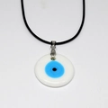 Dettaglio del ciondolo Evil Eye bianco con cerchio blu concentrico e cordino nero sottile - Occhio in Vetro Bianco