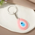 Detail van een roze druppelvormige hars sleutelhanger met het Turkse boze oog symbool - Roze Waterdruppel