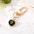 Elegant gold keychain with emerald heart crystal charm on a textured stone surface - 1# Green Crystal Heart