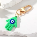 Detalle de llavero de mano de Hamsa verde con ojo turco azul y cierre de metal dorado - Verde