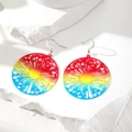 Detail der Regenbogen-Löwenzahn-Ohrringe, präsentiert auf weißem, texturiertem Stein - Ausgehöhltes Sonnenmotiv