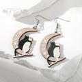 Detail of wooden crescent moon earrings featuring a cute black and white cat pattern - Moon and Cat Style