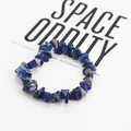 Dettaglio del bracciale bohémien in lapislazzuli su uno sfondo bianco in stile minimalista - Pietre Blu Notte