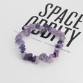 Dettaglio macro di perline di pietra naturale viola irregolari su bracciale elastico - Pietre Viola