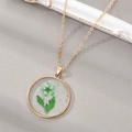 Golden necklace with a round resin pendant featuring green dried flowers and gold leaf foil - March Green Flower (Necklace)