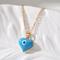 Dettaglio del ciondolo a cuore blu con occhio del male su una catena in acciaio dorato - Blu