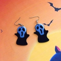 Nahaufnahme der Halloween-Geisterohrringe mit schwarzen Umhängen auf orangefarbenem Grund - Ghostface Schrei (Kreuzhaken)