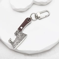 Macro shot of miniature cleaver keychain with Damascus pattern and D-ring buckle detail - Cleaver
