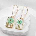 Macro detail of handmade resin square earrings with teal flowers and gold foil elements - Pearl Green Flower