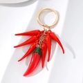 Realistic red chili pepper keychain with golden ring on a clean white background - Chili String