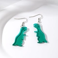 Close-up of green transparent acrylic dinosaur earrings with silver metal hooks on a white plate - Cyan Little Dinosaur (Silver Hook)