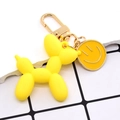 Detail of yellow balloon dog keychain with golden spring clasp and smiley face charm - Yellow Balloon Dog And Smiley Face