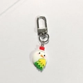 Close-up of a cute cartoon snowman keychain with a red hat and silver metal lobster clasp - Snowman Head