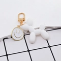 Dettaglio portachiavi cane palloncino bianco opaco con ciondolo smiley dorato e gancio - Cane Palloncino Bianco E Faccia Sorridente