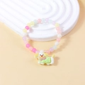 Buntes Makronen-Perlenarmband für Mädchen mit süßem Welpenanhänger und elastischem Band - Pink Gelb Violett Weiße Perlen mit Hund in Grünem Blumendruck