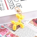 Vibrant yellow balloon dog keychain with glossy finish and gold metal lobster clasp - Metallic Yellow