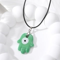Handcrafted green Hamsa pendant necklace with evil eye detail on a black cord - Green Glass Hamsa Hand